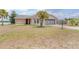 Charming brick home with a well-manicured lawn and a palm tree, located near a lake at 2055 Little Farms Ct, Deltona, FL 32738