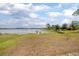 Serene lake view with a wooden dock, grassy lawn, and mature trees at 2055 Little Farms Ct, Deltona, FL 32738
