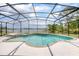 Sparkling pool and hot tub in screened enclosure surrounded by lush landscaping at 2055 Little Farms Ct, Deltona, FL 32738