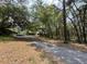 Driveway leading to home amid lush, mature trees providing shade and a scenic approach at 2068 Pennsylvania Dr, Deland, FL 32724