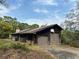 Rustic detached garage with a basketball hoop, surrounded by overgrown vegetation at 2068 Pennsylvania Dr, Deland, FL 32724