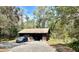 Detached garage with a car parked outside, set in a tranquil, wooded environment at 2068 Pennsylvania Dr, Deland, FL 32724