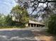 Rustic home with a long driveway surrounded by mature trees and natural landscaping at 2068 Pennsylvania Dr, Deland, FL 32724