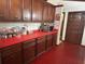 Kitchen featuring wood cabinets, red countertops, and appliances at 2068 Pennsylvania Dr, Deland, FL 32724
