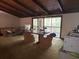 Expansive living room with wood beams, fireplace, and a wall of sliding glass doors at 2068 Pennsylvania Dr, Deland, FL 32724