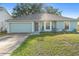 Charming single-story home with a well-maintained lawn and a two-car garage at 2110 3Rd Ave, Deland, FL 32724