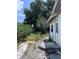 The backyard features greenery and needs landscape maintenance. There is a bicycle and equipment on the patio at 2210 Se 1St St, Orange City, FL 32763