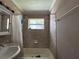 Bathroom with tiled shower/tub combo, vanity, and a window providing natural light at 2210 Se 1St St, Orange City, FL 32763