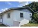 Shows the exterior of the home, highlighting its architectural features and corner lot with limited landscaping at 2210 Se 1St St, Orange City, FL 32763