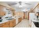 Traditional kitchen with light wood cabinets, white appliances and tile flooring throughout at 2287 Belen Dr, Deltona, FL 32738