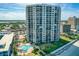 Aerial view featuring a modern condo building with a pool and lush landscaping at 2425 S Atlantic Ave # 1202A, Daytona Beach Shores, FL 32118
