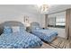 Bright bedroom with two twin beds, stylish bedding, and a modern chandelier at 2425 S Atlantic Ave # 1202A, Daytona Beach Shores, FL 32118