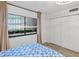 Cozy bedroom featuring a window with leafy view and built in closets at 2425 S Atlantic Ave # 1202A, Daytona Beach Shores, FL 32118