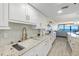 Modern kitchen with granite countertops, white cabinetry, and an ocean view at 2425 S Atlantic Ave # 1202A, Daytona Beach Shores, FL 32118