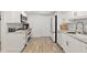 Bright kitchen features white cabinets, stainless appliances, granite counters, and wood-look tile flooring at 2425 S Atlantic Ave # 1202A, Daytona Beach Shores, FL 32118