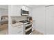 Kitchen features white cabinets, granite countertops, modern appliances, and a view into the bedroom at 2425 S Atlantic Ave # 1202A, Daytona Beach Shores, FL 32118