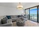 Coastal living room with gray sectional, beachy ottoman, and sliding glass doors to a balcony with ocean views at 2425 S Atlantic Ave # 1202A, Daytona Beach Shores, FL 32118