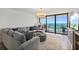 Coastal living room with gray sectional, beachy ottoman, and sliding glass doors to a balcony with ocean views at 2425 S Atlantic Ave # 1202A, Daytona Beach Shores, FL 32118