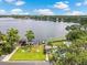 Scenic aerial view of a waterfront property with a private dock, pool, and lush landscaping at 2500 Lee Rd # 134, Winter Park, FL 32789