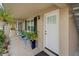 Condo entryway with bright white front door and a cozy front patio with seating and plants at 2500 Lee Rd # 134, Winter Park, FL 32789