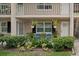 Condo with cozy front patio featuring blue chairs, lush landscaping, and hanging plants at 2500 Lee Rd # 134, Winter Park, FL 32789