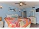 Cozy bedroom with colorful quilt, beach-themed artwork, and ample natural light at 2800 N Atlantic Ave # 206, Daytona Beach, FL 32118