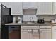 Well-equipped kitchen with white cabinetry, black appliances, and modern fixtures at 2800 N Atlantic Ave # 206, Daytona Beach, FL 32118