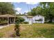 Charming single-story house with white siding, a covered carport, and mature landscaping at 29505 North, Paisley, FL 32767