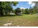 Property showcasing a spacious lawn with scattered trees and a quaint outbuilding at 29505 North, Paisley, FL 32767