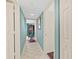 Hallway with light blue walls and white tile floors leading to bedroom at 2967 S Atlantic Ave # 202, Daytona Beach Shores, FL 32118