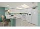 Bright kitchen with white cabinetry, white appliances, bar seating, and tile flooring at 2967 S Atlantic Ave # 202, Daytona Beach Shores, FL 32118
