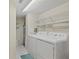 Bright laundry room with white appliances and shelving for optimal storage solutions at 2967 S Atlantic Ave # 202, Daytona Beach Shores, FL 32118