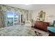 Main bedroom with floral bedding has an ocean view and dark wood floors and trim at 2967 S Atlantic Ave # 202, Daytona Beach Shores, FL 32118