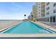 Large community pool with ocean view and several lounge chairs available for residents at 2967 S Atlantic Ave # 202, Daytona Beach Shores, FL 32118