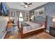 Cozy bedroom featuring wood floors, a ceiling fan, and a large window with decorative curtains at 3001 Inca Ct, Deltona, FL 32738