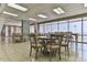 Bright dining area with multiple tables, chairs, and floor-to-ceiling windows offering stunning views at 3003 S Atlantic Ave # 21A2, Daytona Beach Shores, FL 32118