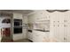 Kitchen with white appliances and ample storage and a view into the living room at 3003 S Atlantic Ave # 21A2, Daytona Beach Shores, FL 32118