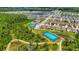 Wide aerial shot showcasing community tennis courts and ponds amidst a residential area and lush green landscape at 3049 Meleto Blvd, New Smyrna Beach, FL 32168