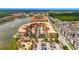 High-angle shot of a multi-colored condo complex with a lake, fountains, parking, and tropical landscaping at 3049 Meleto Blvd, New Smyrna Beach, FL 32168