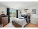 Comfortable bedroom with a large window, dresser, decorative pillows, and football decor at 3049 Meleto Blvd, New Smyrna Beach, FL 32168