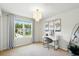 Bedroom featuring a modern chandelier, a vanity desk with mirror and natural light from the large window at 3049 Meleto Blvd, New Smyrna Beach, FL 32168