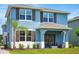Charming blue two-story home with brown shutters, a covered front porch, and well-manicured lawn at 3049 Meleto Blvd, New Smyrna Beach, FL 32168