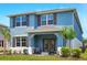 Charming blue two-story home with brown shutters, a covered front porch, and well-manicured lawn at 3049 Meleto Blvd, New Smyrna Beach, FL 32168