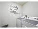 Laundry room with a washing machine, a dryer, and a modern decorative laundry sign at 3049 Meleto Blvd, New Smyrna Beach, FL 32168