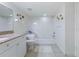 Well-lit bathroom has ceramic tiled floor, white cabinets, granite counters and bathtub with shower at 3145 S Atlantic Ave # 503, Daytona Beach Shores, FL 32118