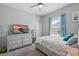Cozy bedroom with soft gray walls, a ceiling fan, and a bed with a decorative patterned cover at 3229 Medici Blvd, New Smyrna Beach, FL 32168