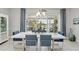 Elegant dining room with modern table, seating and outdoor view of the pool and patio at 3229 Medici Blvd, New Smyrna Beach, FL 32168