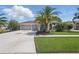Well-maintained home featuring a three-car garage, manicured lawn, and tropical landscaping at 3229 Medici Blvd, New Smyrna Beach, FL 32168