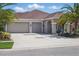 Inviting home featuring a three-car garage, covered porch, and well-manicured lawn at 3229 Medici Blvd, New Smyrna Beach, FL 32168