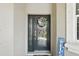Front entryway featuring sidelight window, wreath, blue welcome sign, and storm door at 3229 Medici Blvd, New Smyrna Beach, FL 32168